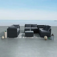 Outdoor modular lounge set with couch, ottoman, and rug on the beach