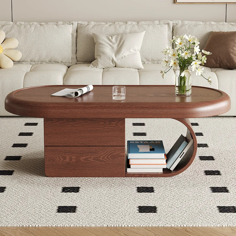 Wooden coffee table with books and a vase of flowers in a living room setting.