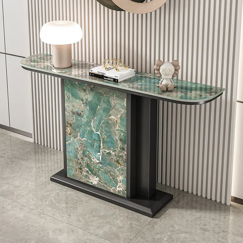 Console table with marble design and decorative items against a striped wall.