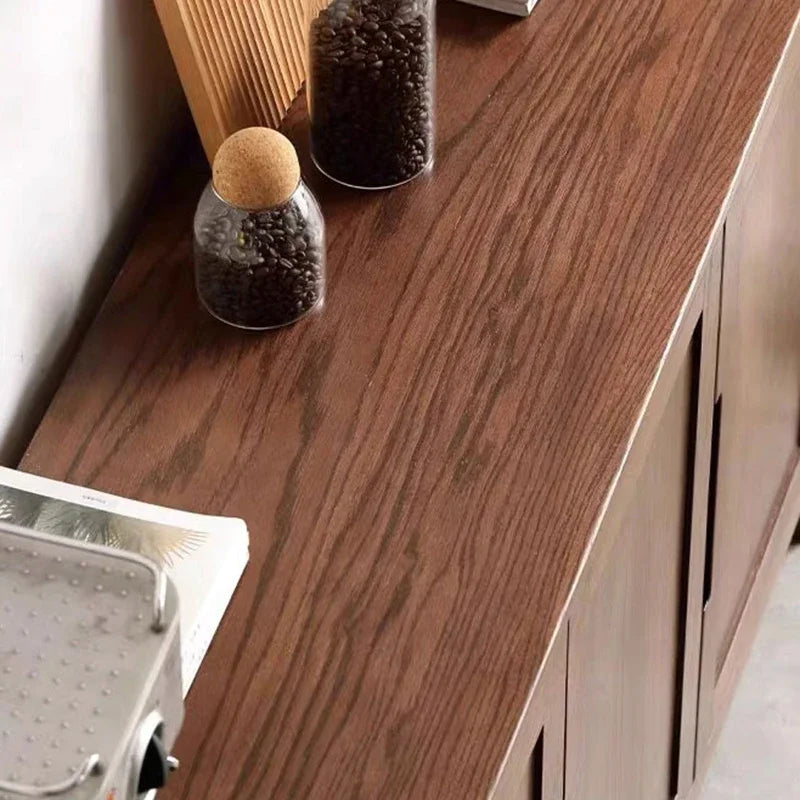 Wooden surface with two glass jars containing coffee beans and a wooden board.