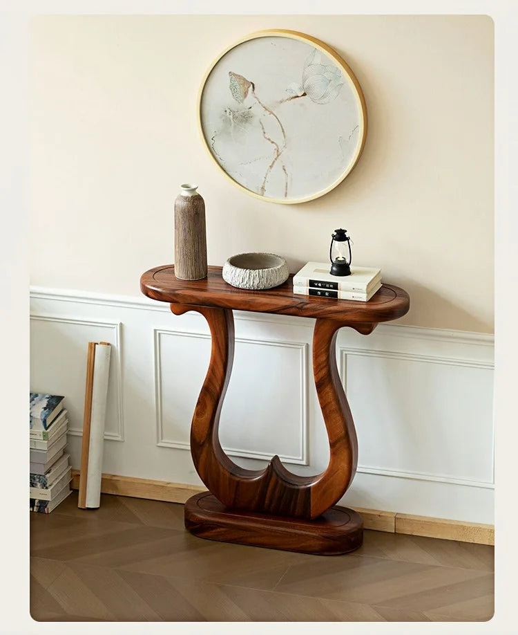 Wooden console table with decorative items against a wall with a clock.
