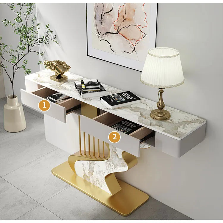 Modern console table with marble design and gold accents, featuring drawers and decorative items.