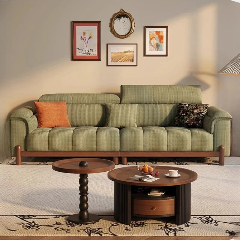 Green sofa with wooden coffee table and decorative items in a living room setting.