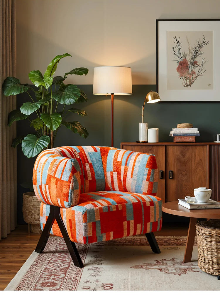 Modern living room with a colorful armchair, lamp, and decor items.