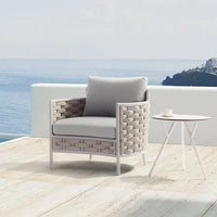 Outdoor chair with cushion and small table on a deck with ocean view