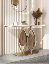 Decorative console table with leaf design legs against a neutral wall.