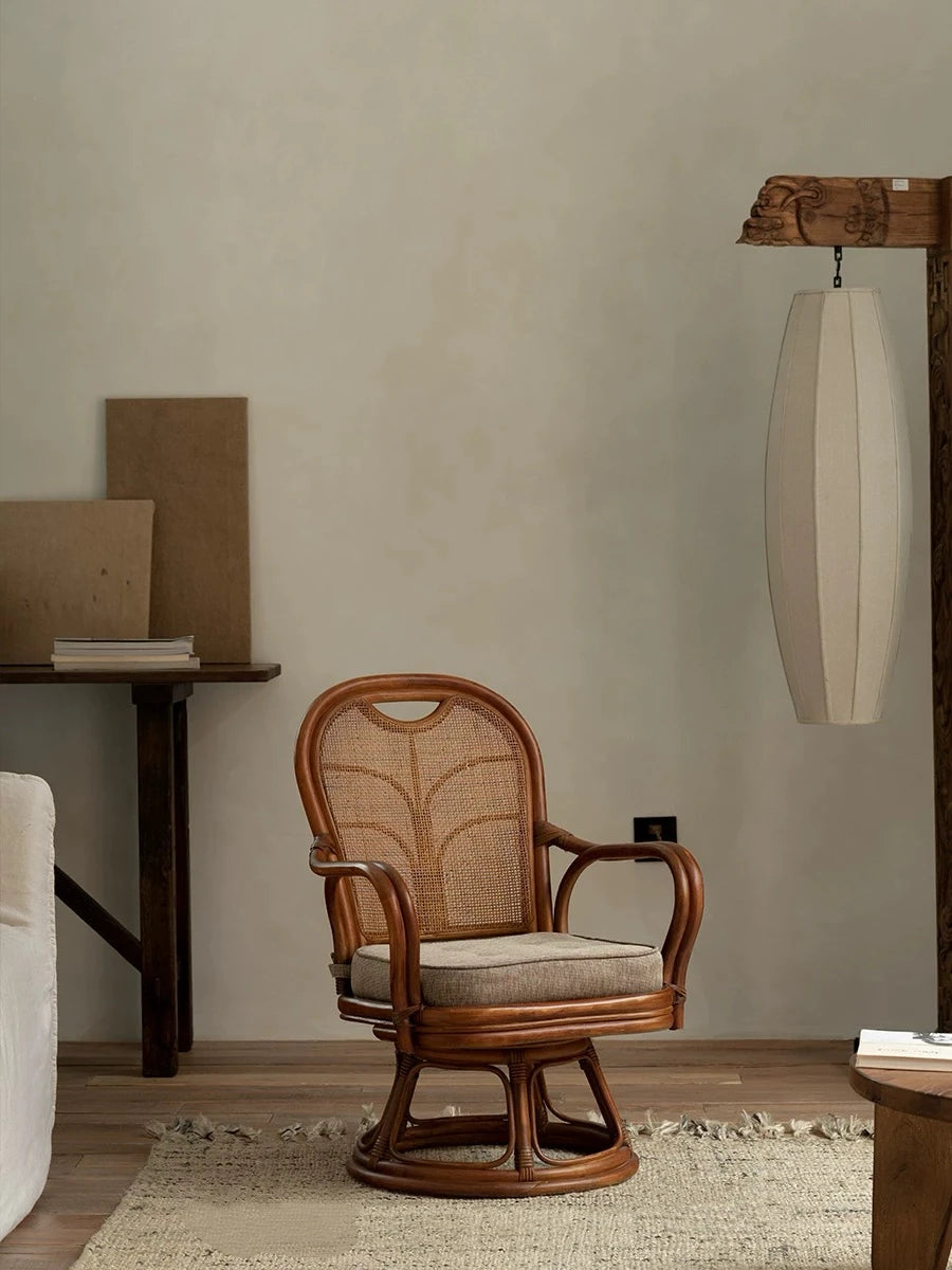 Wooden swivel chair with woven backrest in a room setting.