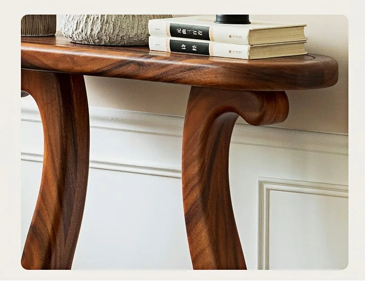 Wooden console table with books on a white wall background