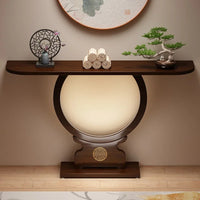 Decorative console table with a spherical lamp and small plants in a room setting.