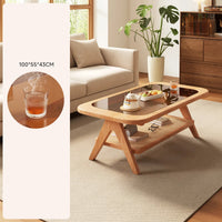 Wooden coffee table in a living room with a plant and a glass of tea.