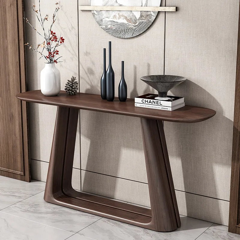 Wooden console table with decorative items against a neutral wall.