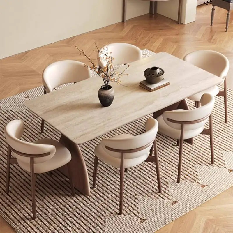 Dining table set with chairs in a room with wooden flooring and a rug.
