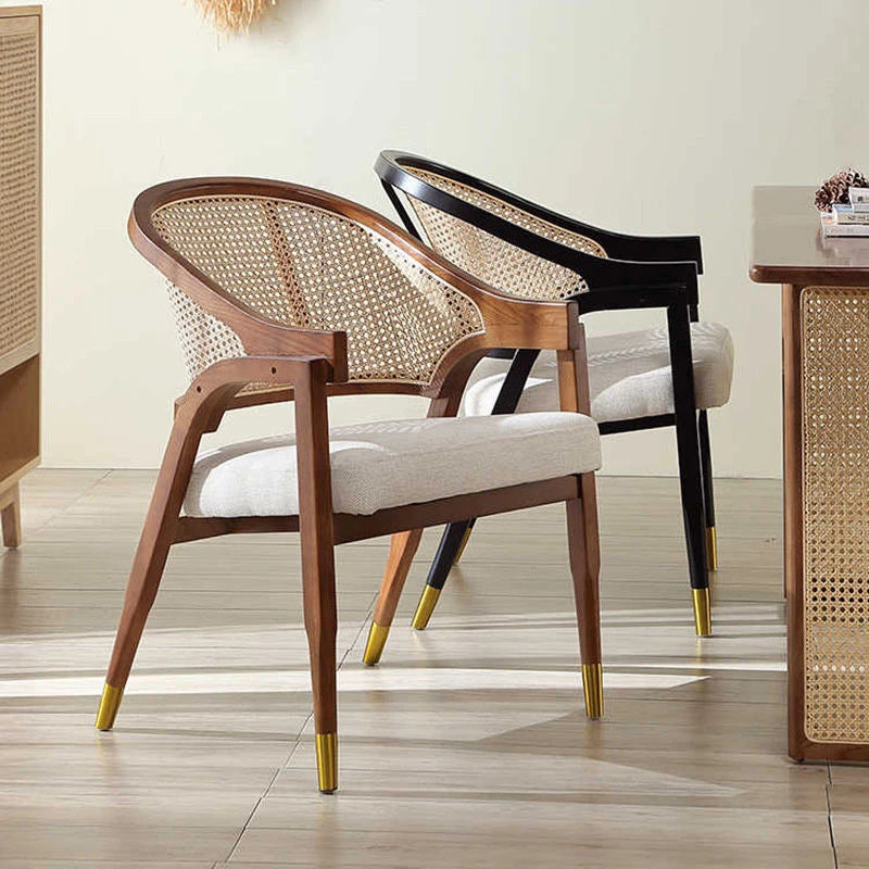 Wooden chairs with cane backrests and gold feet in a room setting.