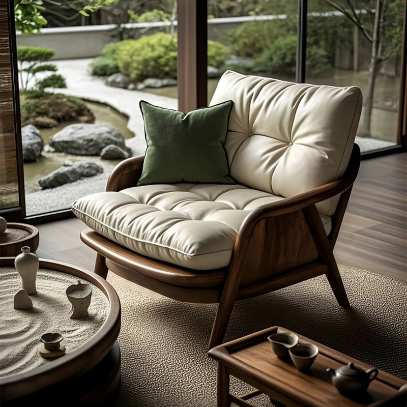 Wooden armchair with cushions in a room with a view of a garden.