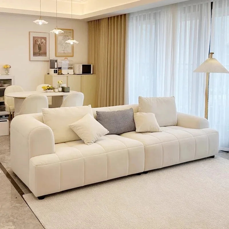 Modern living room with a beige sofa and decorative pillows.