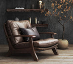 Brown leather armchair in a room with dark walls and decorative elements.
