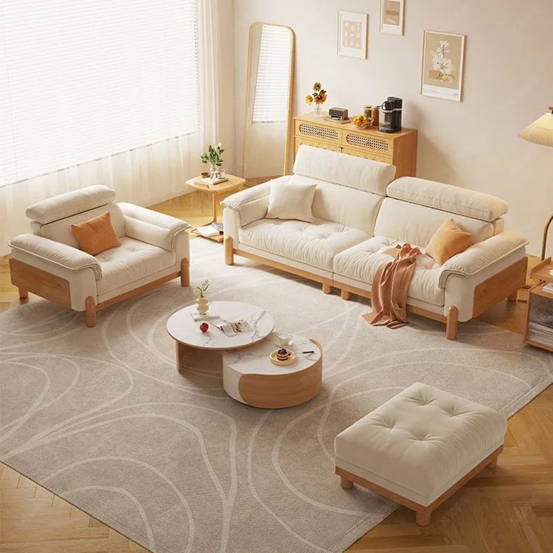 Modern living room with beige sofa set and coffee table on a patterned rug.
