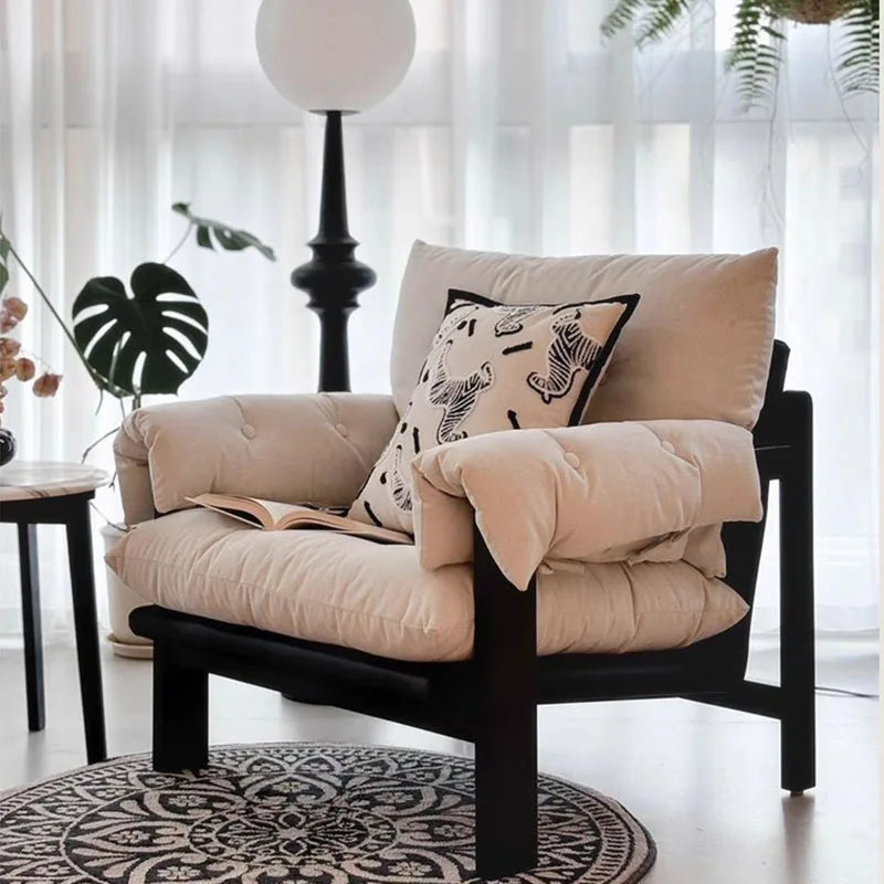 Beige armchair with cushions and a blanket in a bright room