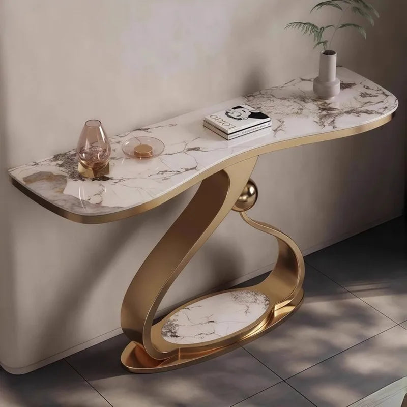 Modern console table with marble top and gold base against a neutral wall.