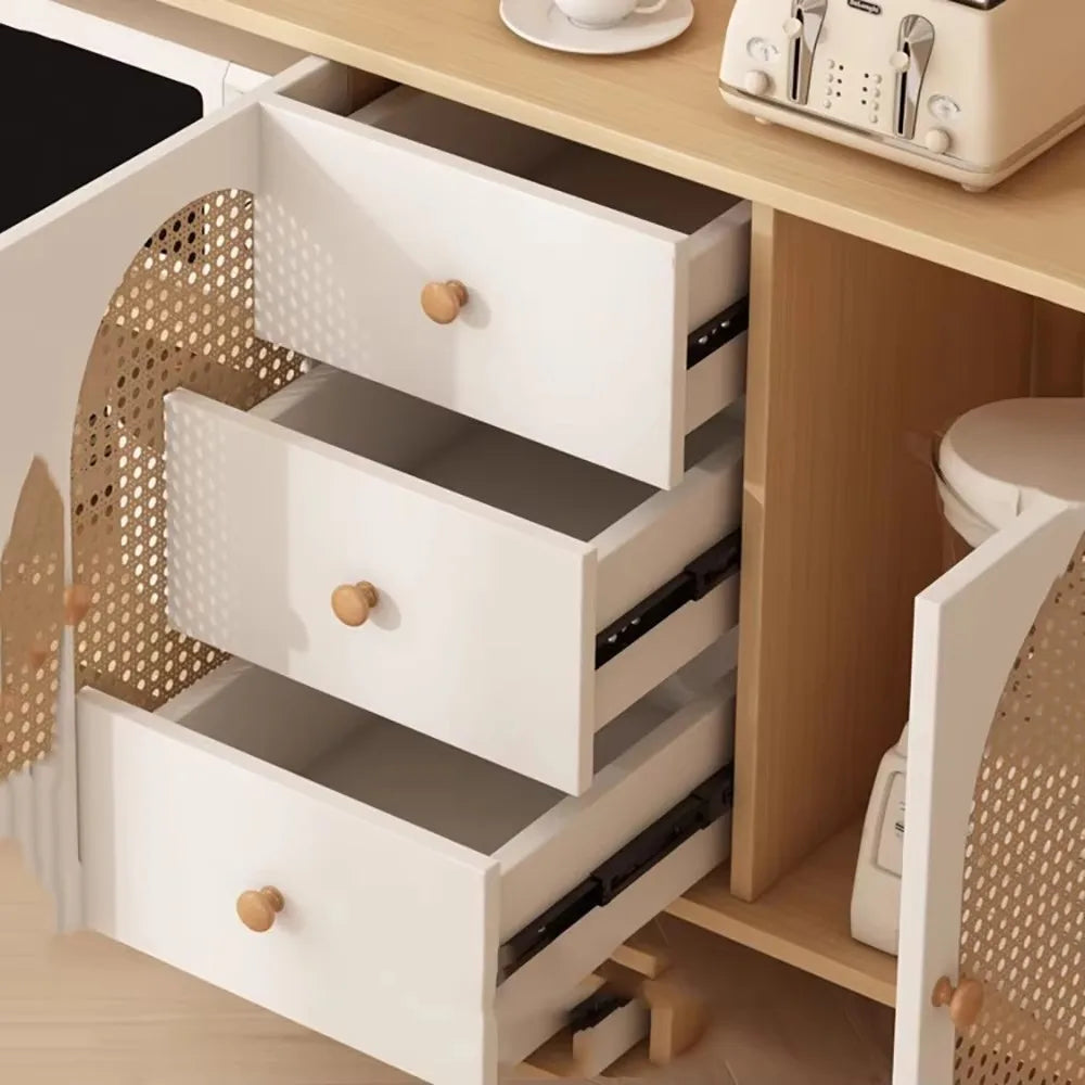 White kitchen cabinet with open drawers and a toaster on a wooden countertop.