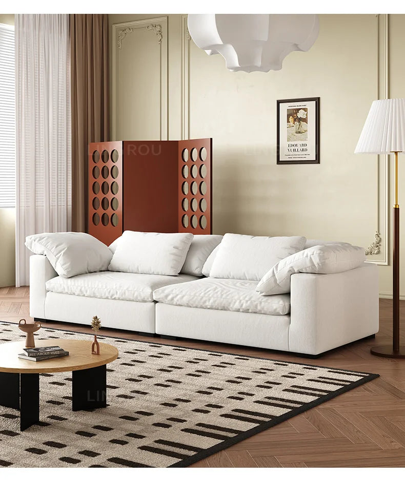 Modern living room with a white sofa, coffee table, and decorative elements.