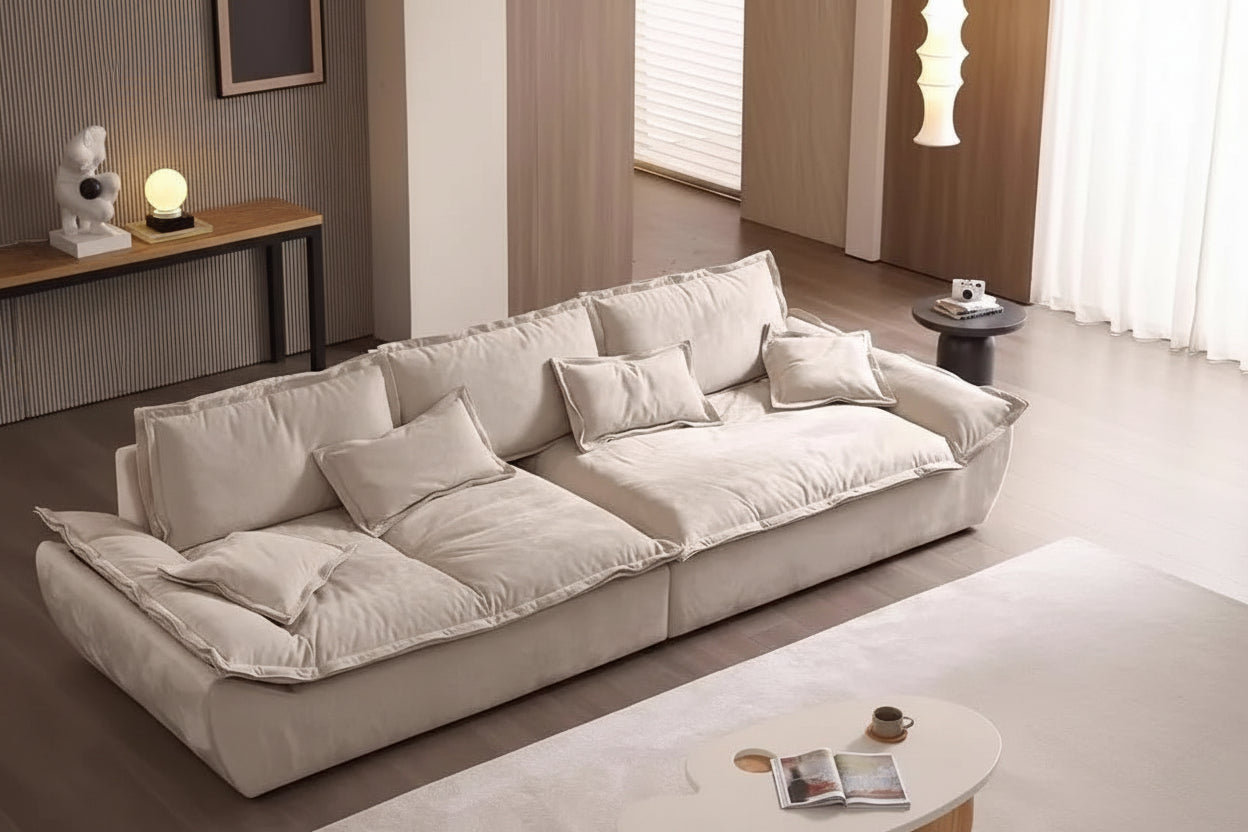 Woman sitting on a large beige sofa in a modern living room.