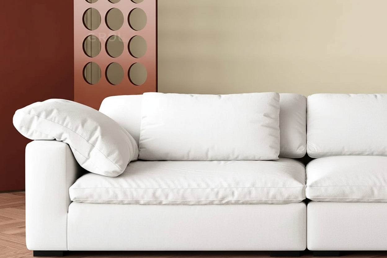 White sofa in a room with a geometric wall art piece and a small table.