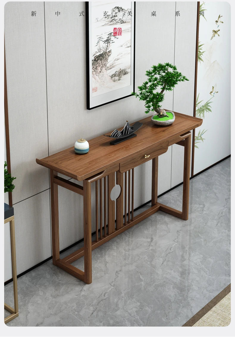 Wooden console table with decorative items against a wall with a framed picture.