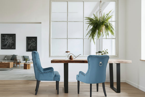 Dining room with blue chairs and a wooden table, featuring text about property styling.