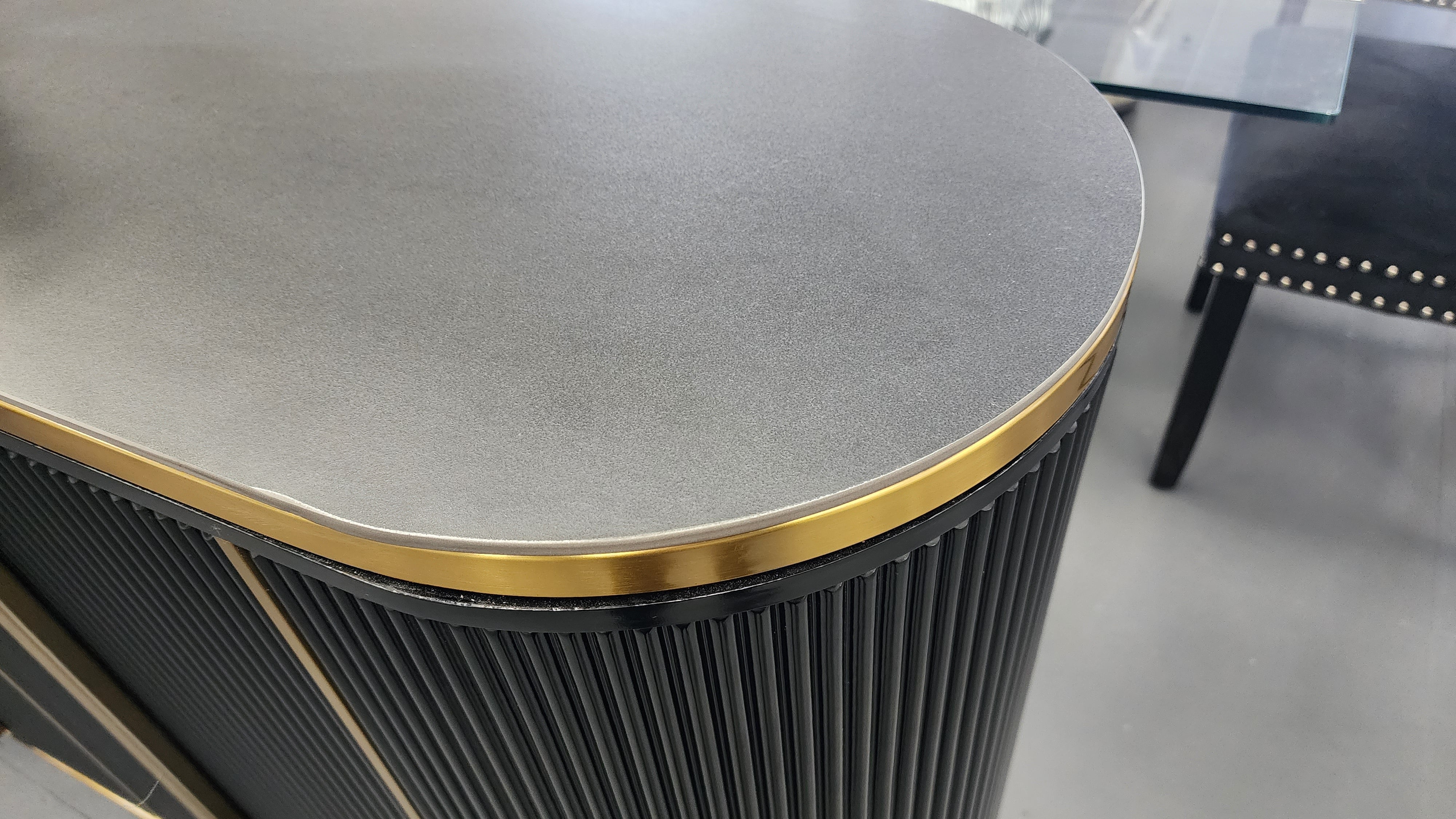 Round table with a gray top and gold rim in an indoor setting