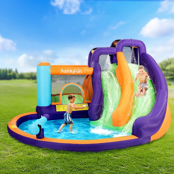 Children playing in an inflatable water park with a slide and pool on a grassy field.