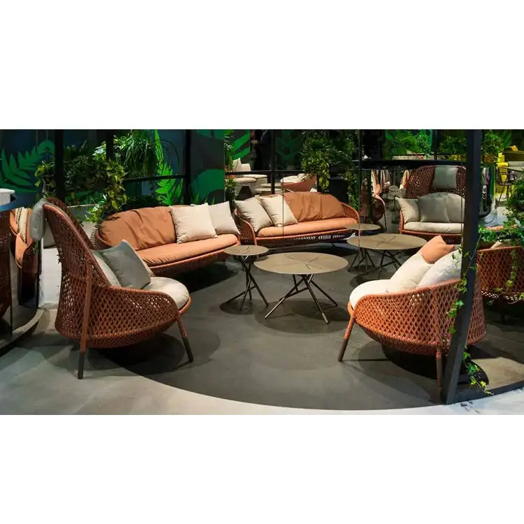 Outdoor furniture set with wicker chairs and tables in a garden setting.