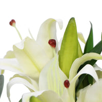 Beautiful artificial white lily in glass vase with green leaves and red spots