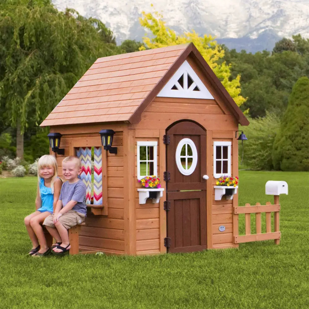 Young girl playing in natural cedar wood aspen cubby house with flower pot holders