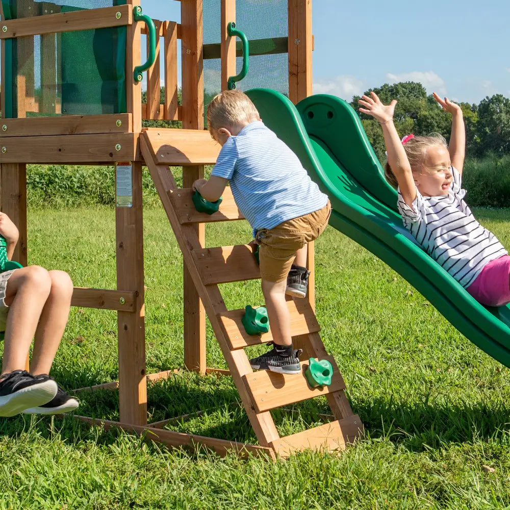Two children playing on a wooden slide at buckley hill play centre