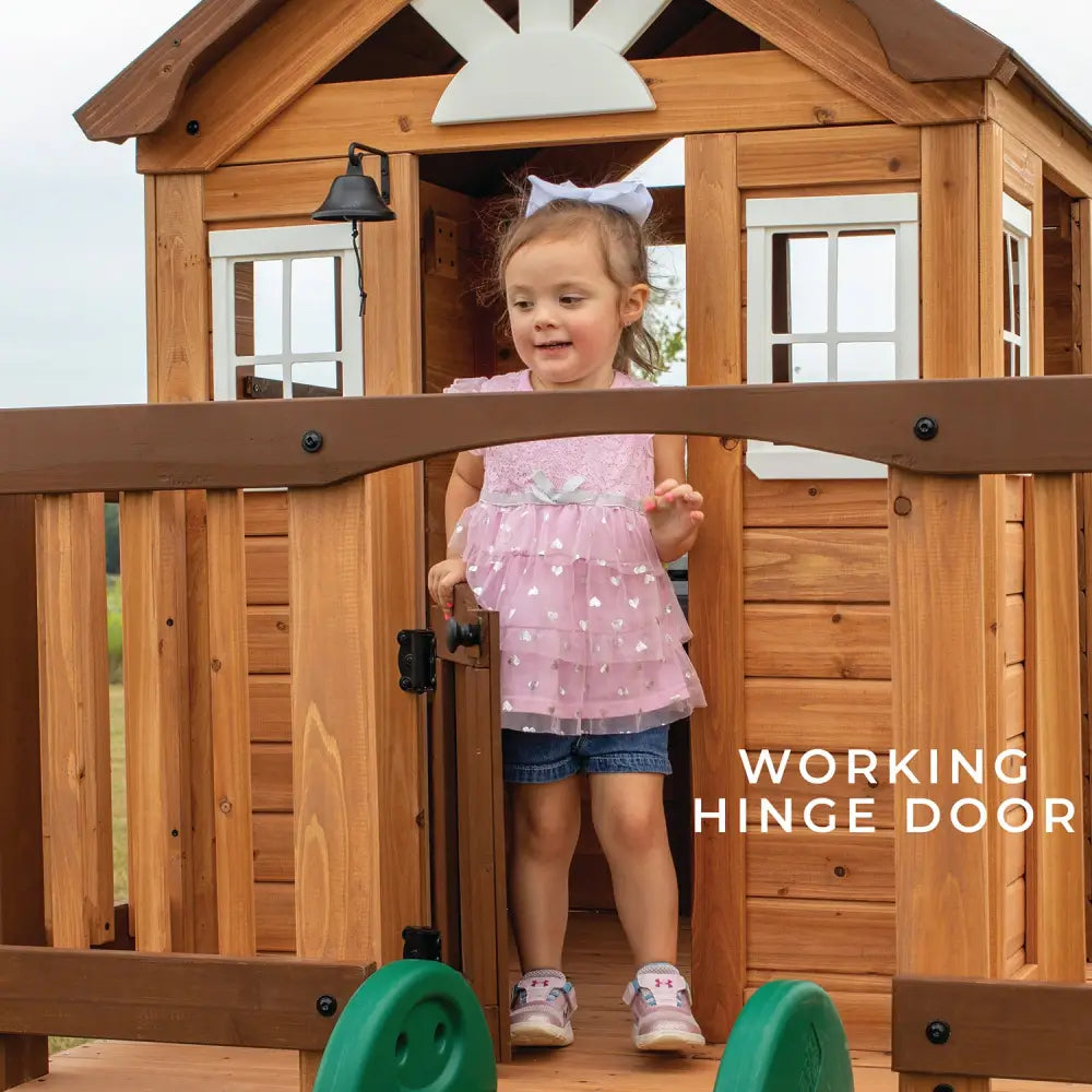Backyard discovery wooden echo heights cubby house with slide: little girl playing in wooden playhouse