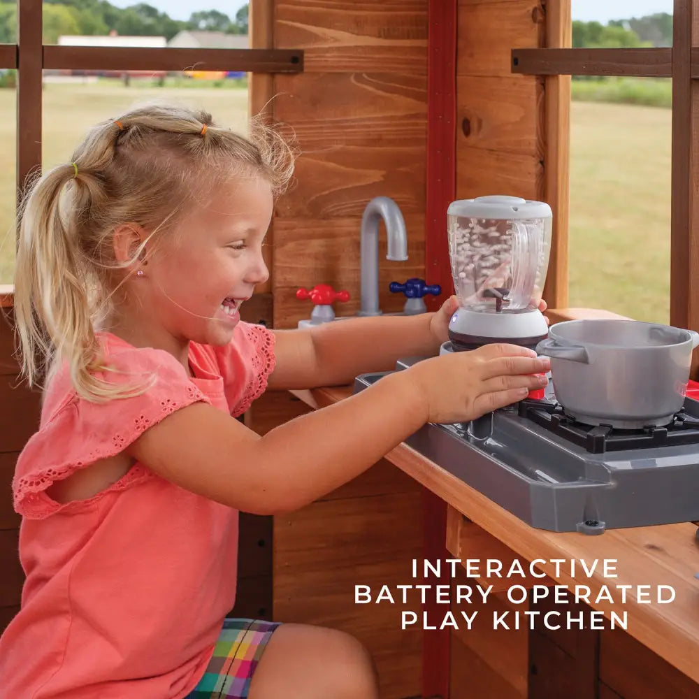 Backyard discovery wooden echo heights cubby house with slide: little girl playing with toy stove