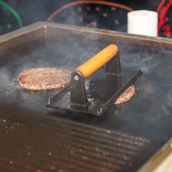 Cast iron grill cooking a hamburger on bbq heavy duty cast iron grill burger press