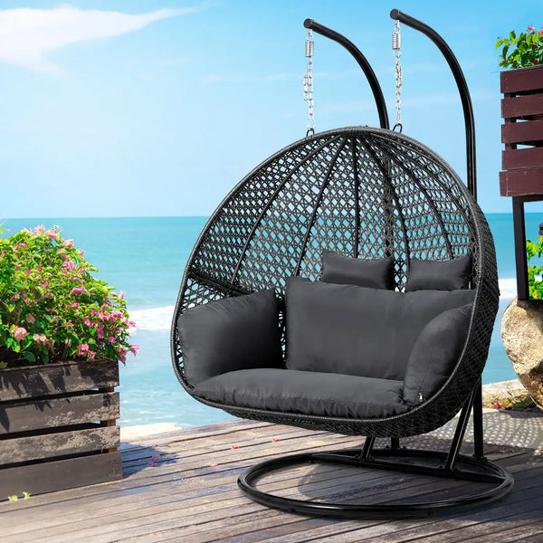 Double hanging egg chair with stand - grey: hand-woven black hanging chair on wooden deck
