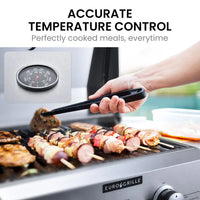 Person grilling chicken on stainless steel portable gas bbq grill