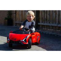 Little boy riding on red ferrari inspired 12v ride-on electric car