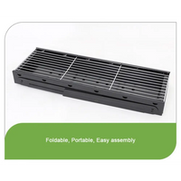 Foldable portable bbq charcoal grill with black metal grate on green background