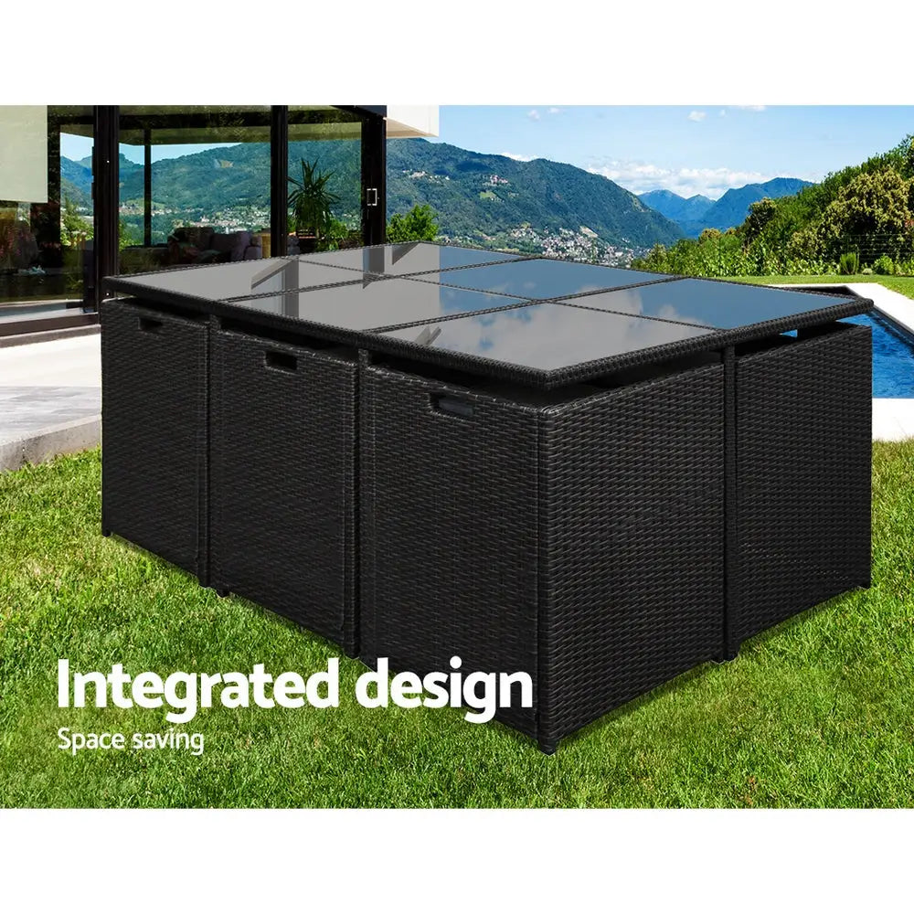 Black wicker outdoor dining set with glass top storage box on grass