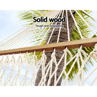 Solid wooden hammock with palm tree in the background