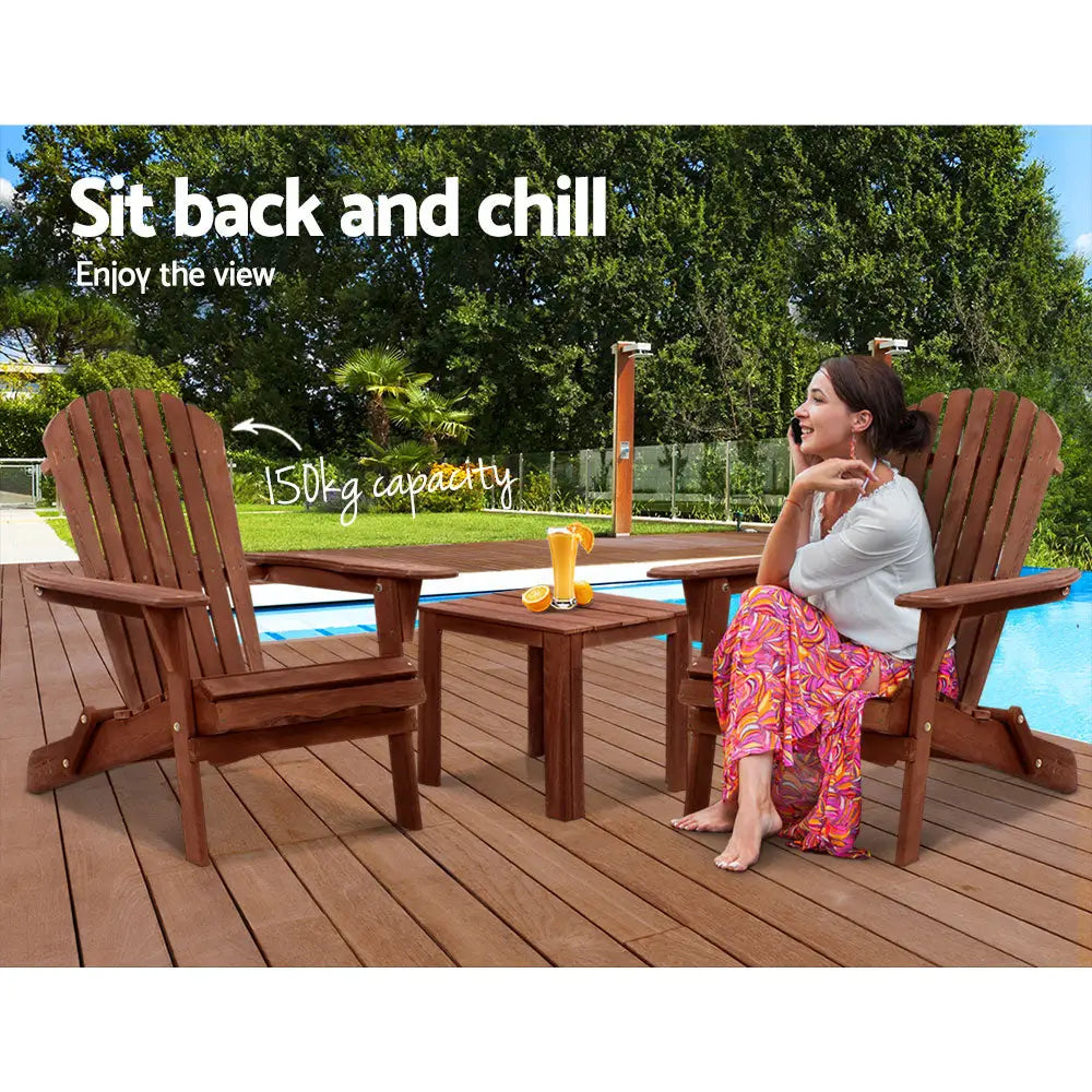 Gardeon 3pc adirondack outdoor table and chairs wooden foldable - brown: woman relaxes by pool on wooden deck