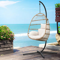 Gardeon foldable wicker swing egg chair with steel stand overlooking ocean