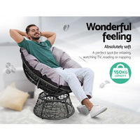 Man relaxing in a gardeon outdoor papasan chair with feet up