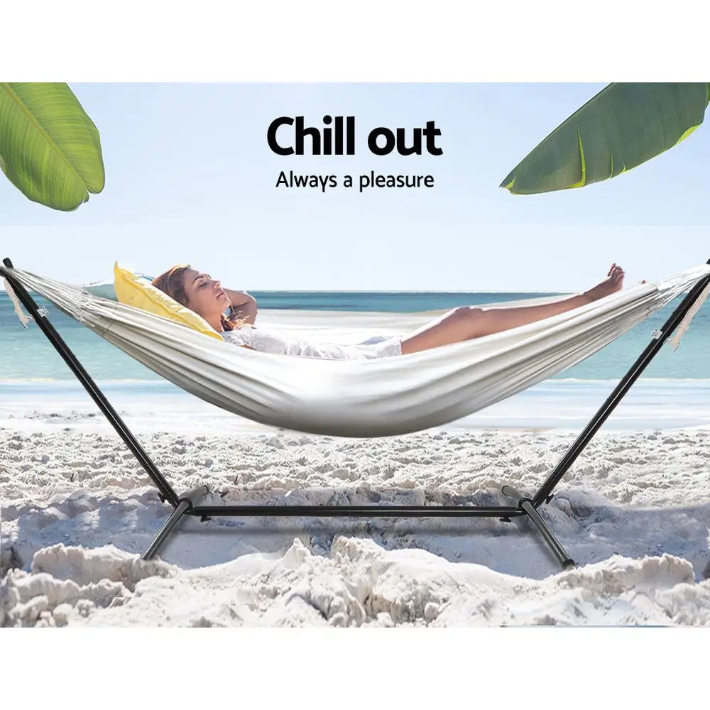 Woman relaxing in a cream hammock with steel stand on the beach