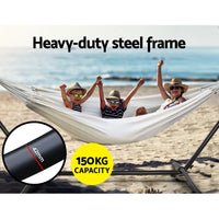 Gardeon single hammock bed with steel stand - cream, featuring two girls relaxing in a hammock on the beach
