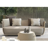 Outdoor sofa set with cushions and a small table in a garden setting, featuring the brand 'ENUROY'.